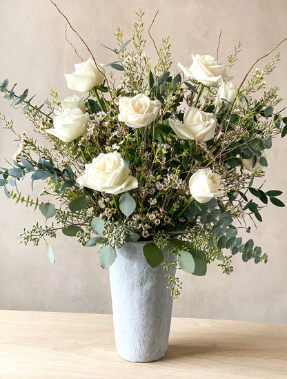 A designer vase filled with roses and greenery for Mother's Day flower delivery throughout Carmel and Pebble Beach