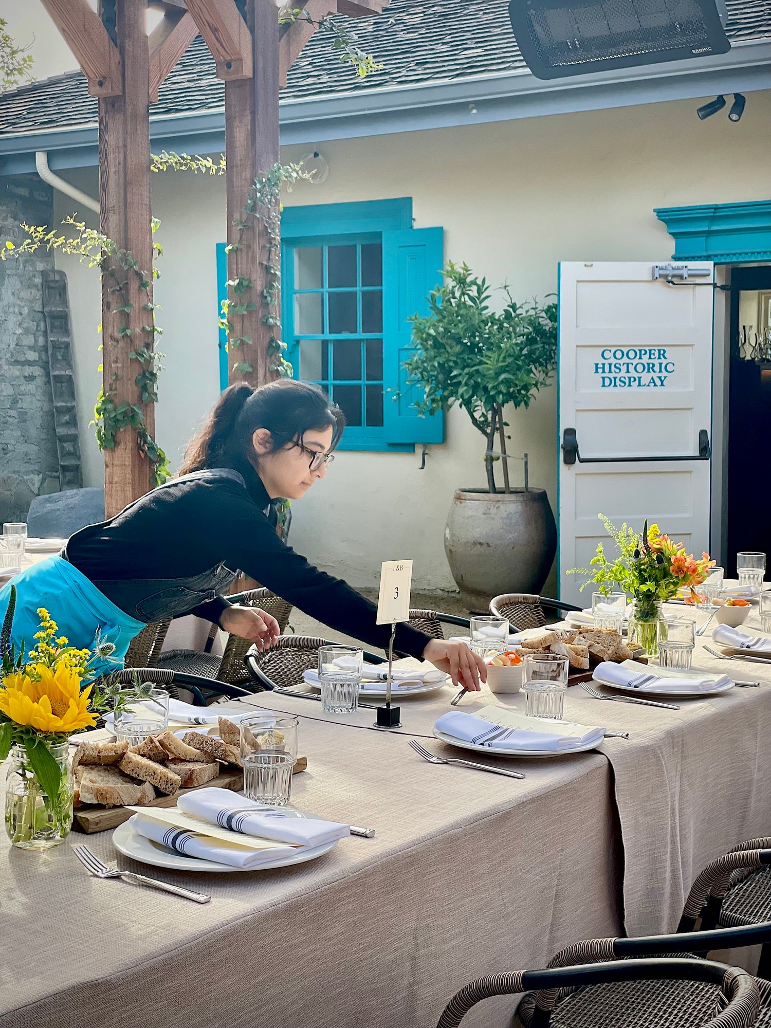 Wedding florist decorating reception table at Cella Restaurant