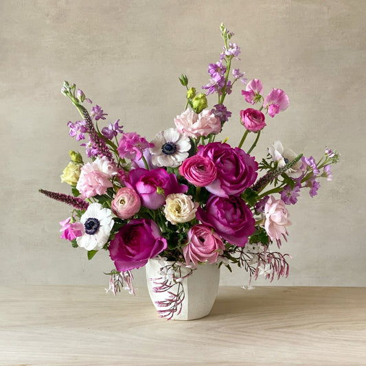 Lush floral arrangement featuring roses, ranunculus, and peonies in tonal pink hues crafted by a local Carmel florist